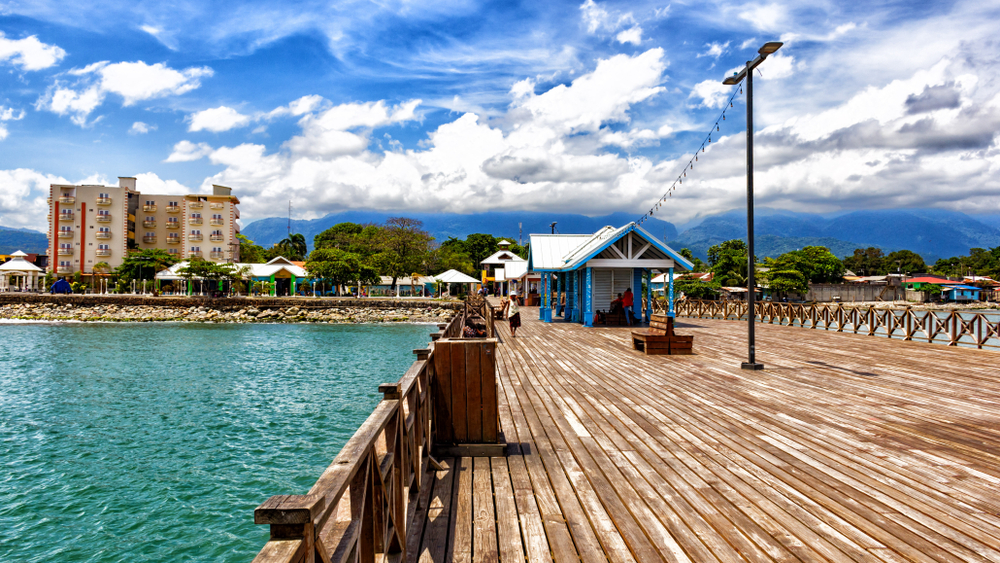 Beautiful and empty port of La Ceiba, a top pick for places to visit in Central America, pictured with its long wooden boardwalk leading up to the downtown area
