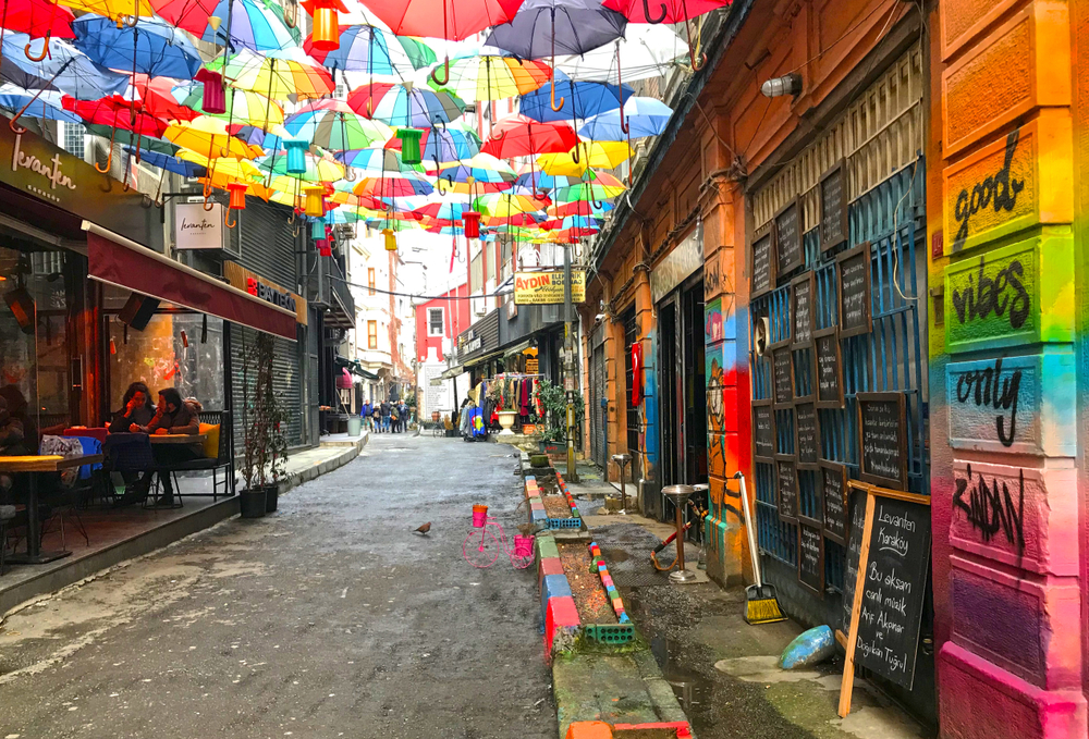 A bunch of colorful umbrellas pictured hanging over the walking path next to the open-air restaurants in Karakoy, one of our top picks when considering where to stay in Istanbul