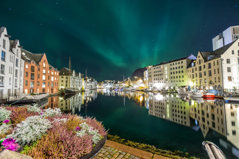 For a roundup of the best places to visit in Norway, a photo of the green sky of the northern lights over Aalesund, one of Norway's best places to visit