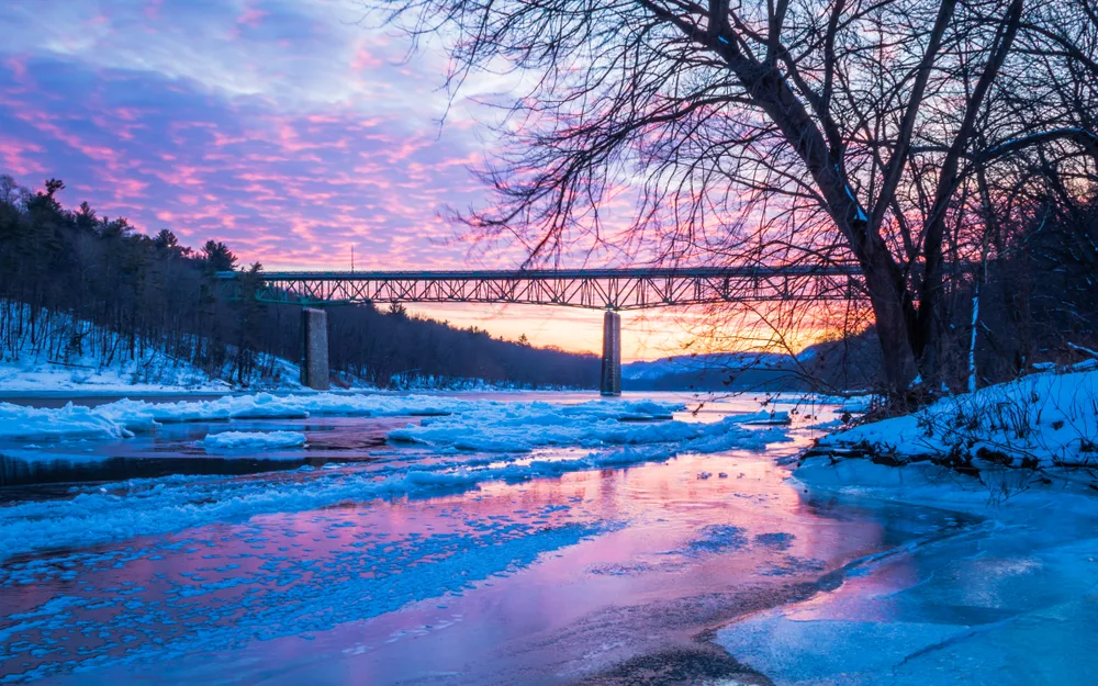 Icy bridge over the river in Milford, Delaware, pictured on a clear day with the sun setting in the background
