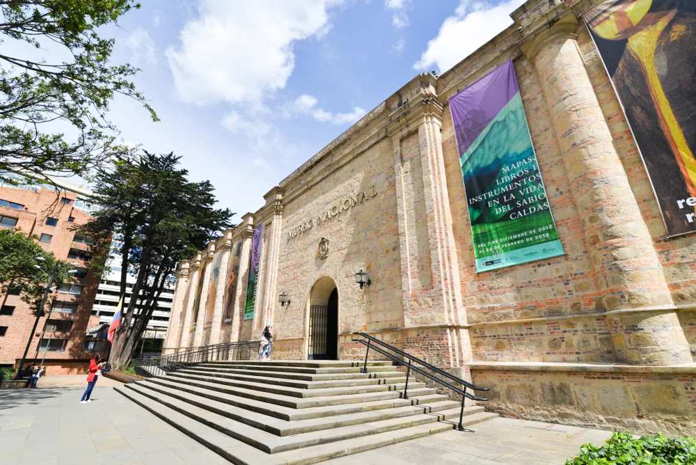For a roundup of the best places to visit in Colombia, an exterior photo of the Museo Nacional de Colombia with clouds overhead