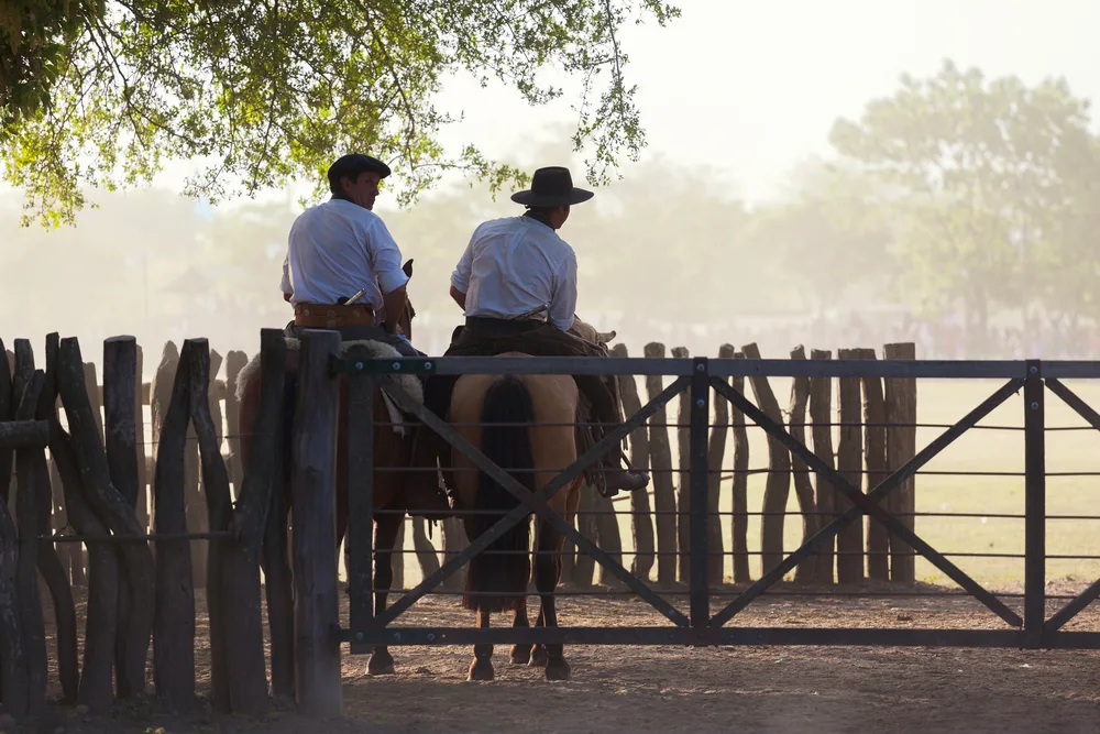 Two cowboys on horses in a pen at San Antonio De Areco, a top pick for places to visit when in Argentina