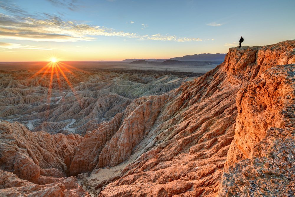 Man standing on a cliff above the valley of Anza-Borrego Desert State Park, one of the best places to visit when on a trip to Southern California