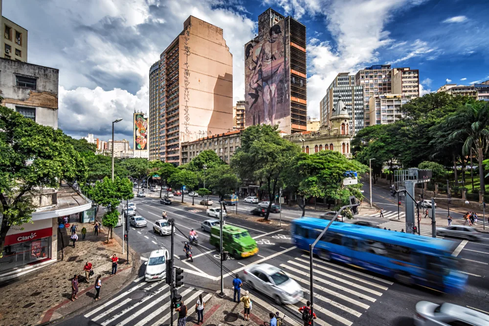 View of a blue bus and a green armored car as seen from a traffic light in downtown Belo horizonte, one of Brazil's must-visit places