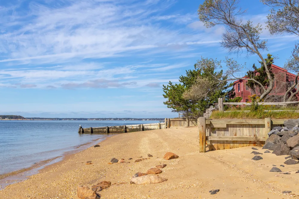 Small red cottage on the tan sandy beach in Shelter Island, one of our top picks for NYC day trips