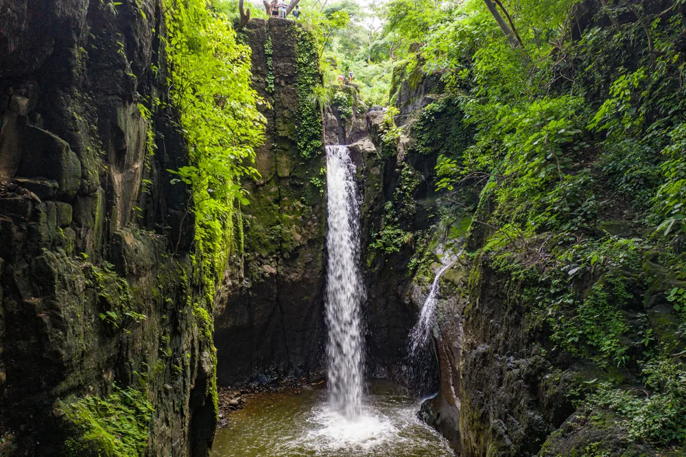 For a roundup of the best places to visit in El Salvador, the Tamanique Falls are pictured from the top of the rocky cliff looking down