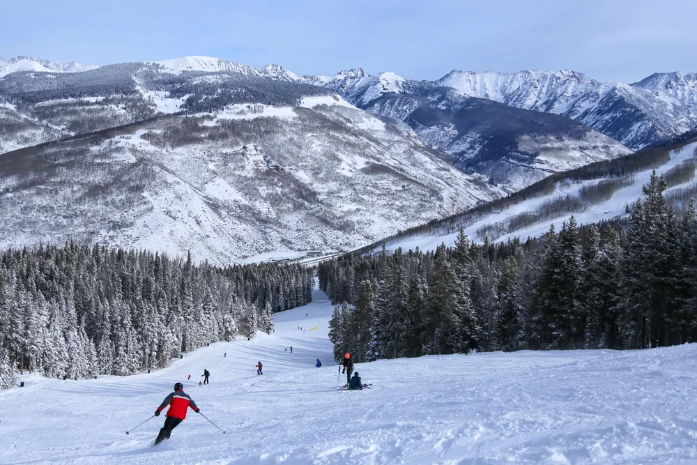 People skiing downhill on a run in Vail, one of the best places to visit during Christmas in the USA