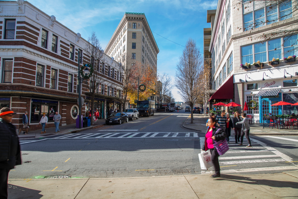 For a piece on the best places to visit during Christmas in the USA, pictured is a woman walking along the streets with shopping bags on her back and a fork in the street in front of the photographer