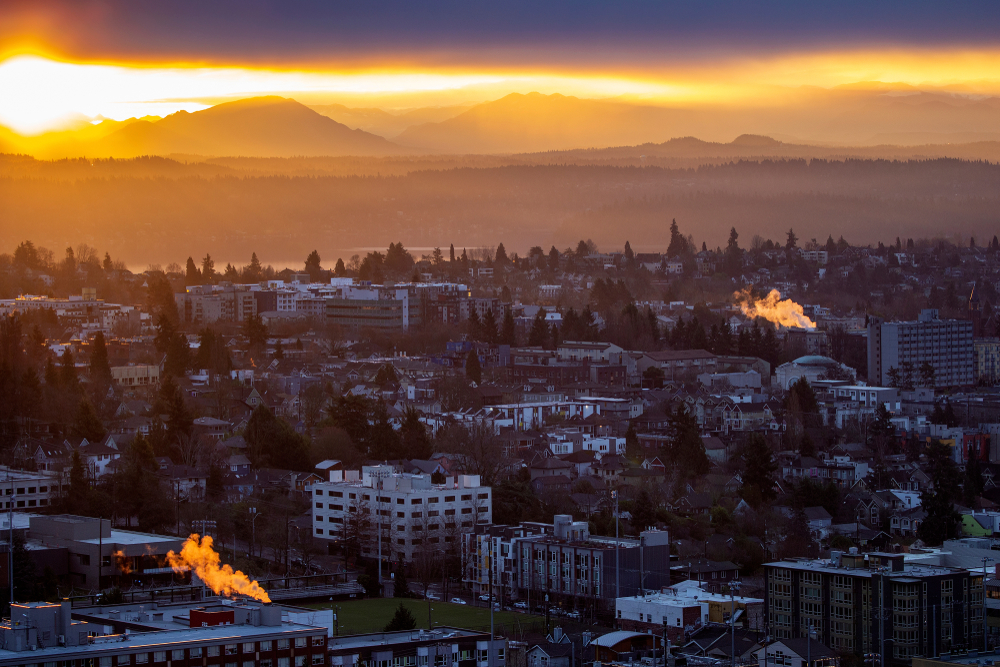 Gorgeous view of the sun setting over the Capitol Hill neighborhood with an orange sky in the background for a piece titled the Best Hotels in Seattle