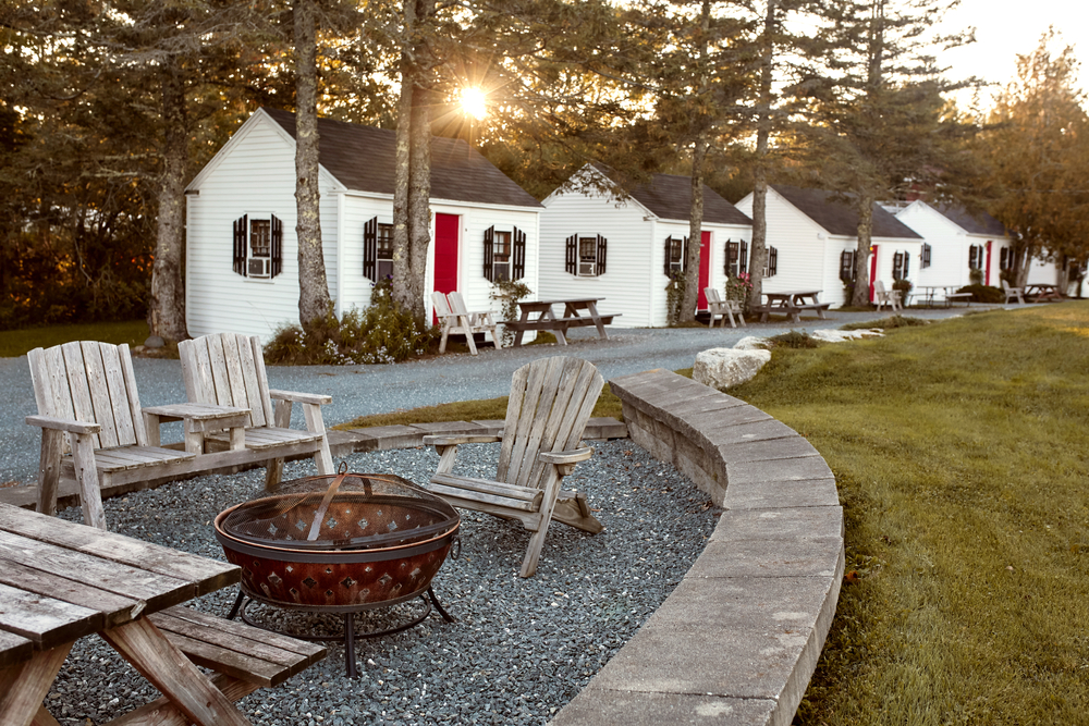 Cute and quaint little cottages lining a gravel walking path in front of some grass in Trenton, Maine, a great place to stay when going to Acadia National Park