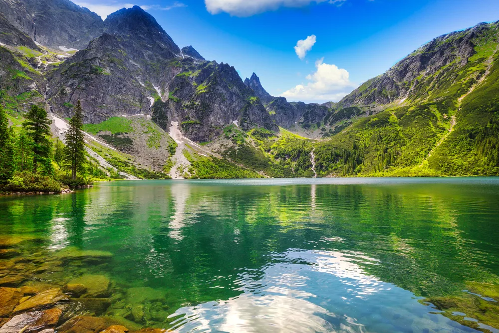As part of a roundup of Poland's best places to visit, pictured is still water in a lake in the Tatra Mountains