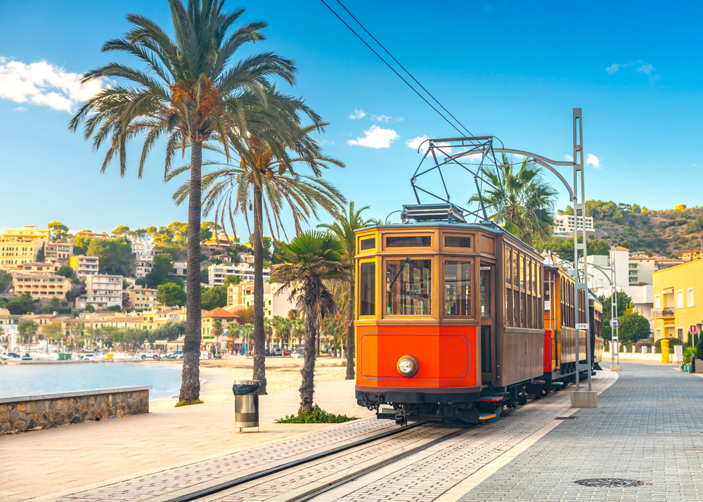 Old wooden train running by the beach in Soller, one of the best areas to stay in Mallorca
