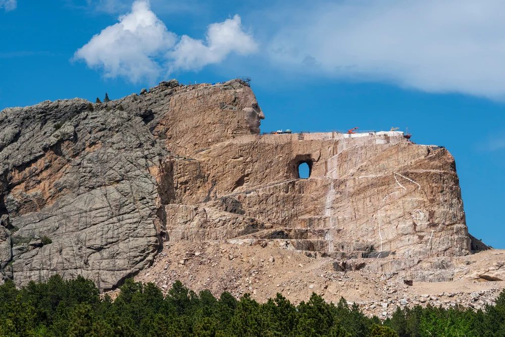 Iconic view of the Crazy Horse Memorial carved into a rock face on a clear summer day