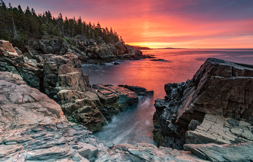 Sunrise over Acadia National Park, looking at the ocean from the edge of the rocky cliff