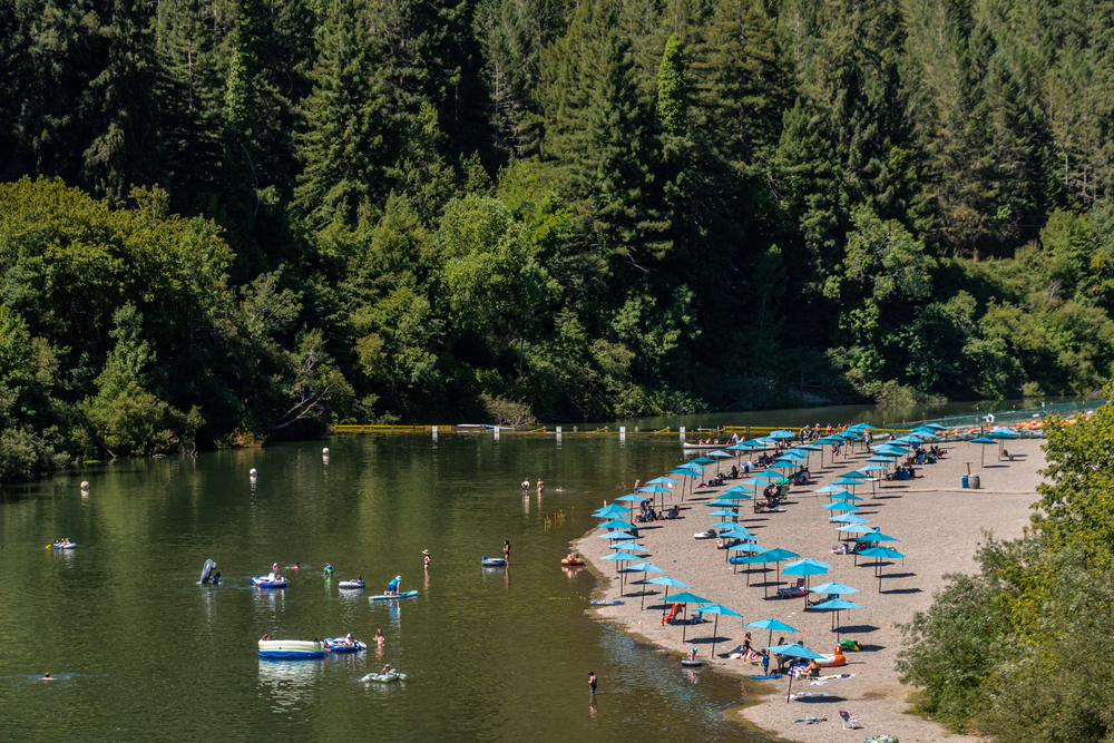 People lying out on Johnson's Beach on the Russian River, one of the best places to visit in California