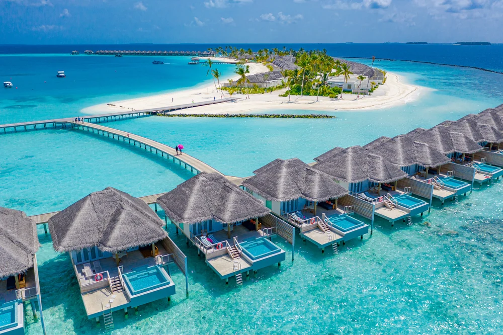 Luxury water villas shown from aerial view of the best islands in the Maldives with white sand beaches in the background