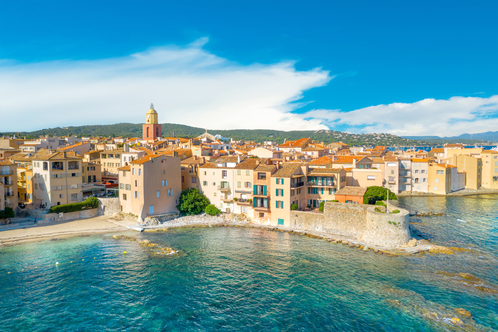 Bay view of St. Tropez in France, one of the best areas to visit on a vacation here, with medieval walls blocking the ocean from the town