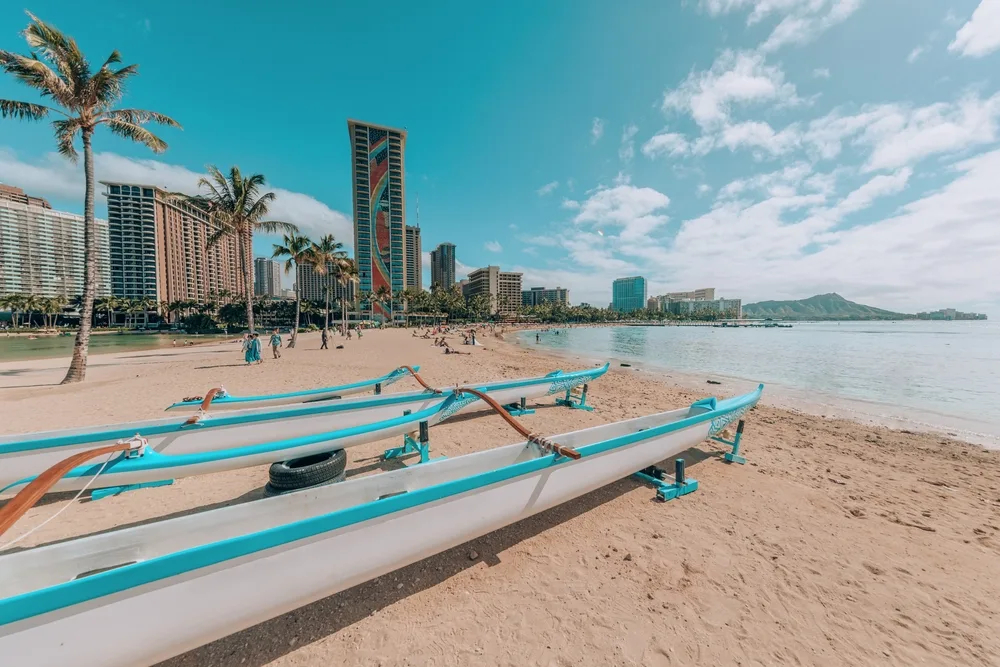 Outrigger boats on a beach in Waikiki Bay in front of some of the best hotels in Hawaii