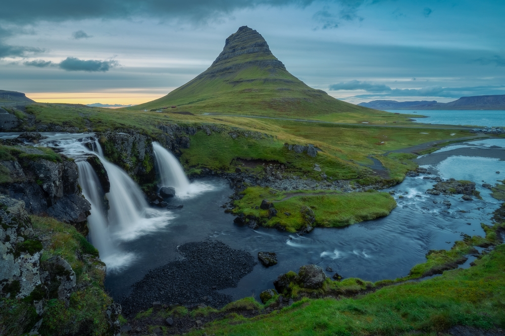 Aerial view of the lush green landscape of the Snæfellsnes, one of the best places to visit on a trip to Iceland, with waterfalls and river along the green hills