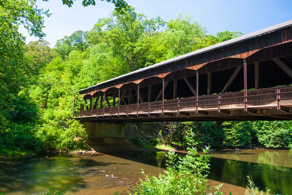 Wooden bridge spanning the river in the forest of Mohican State Park, pictured in the middle of the summer