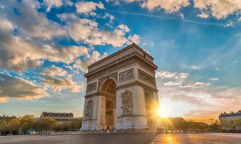 Champs Elysees pictured at dusk with the Arc de Triomphe towering over the reader