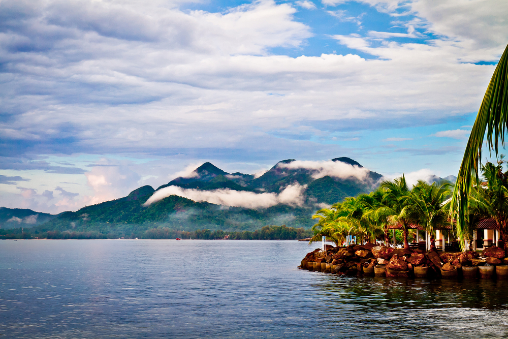 Clouds move in over a volcano that towers up from the ocean in Ko Change, a must-see place on a trip to Thailand