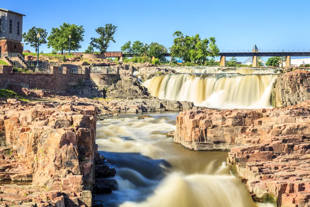 Idyllic view of the breathtaking natural beauty of Falls Park, one of the best places to visit in South Dakota, as seen during the summer with murky water flowing over the rocks