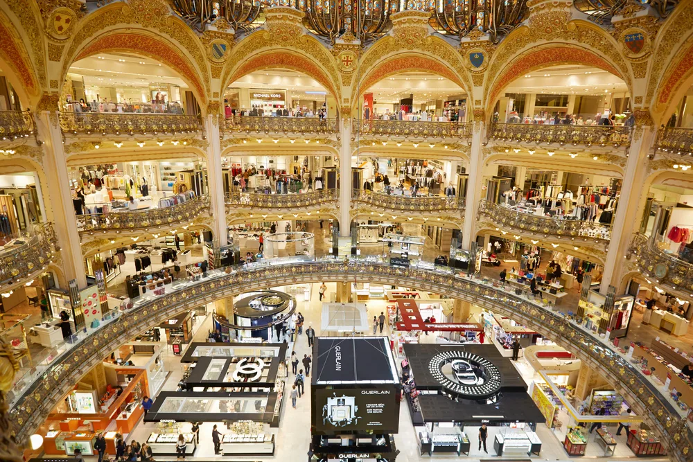 Interior photo of the Galeries Lafayette, one of the best places to visit in Paris, pictured with multiple floors of shops under a single mall