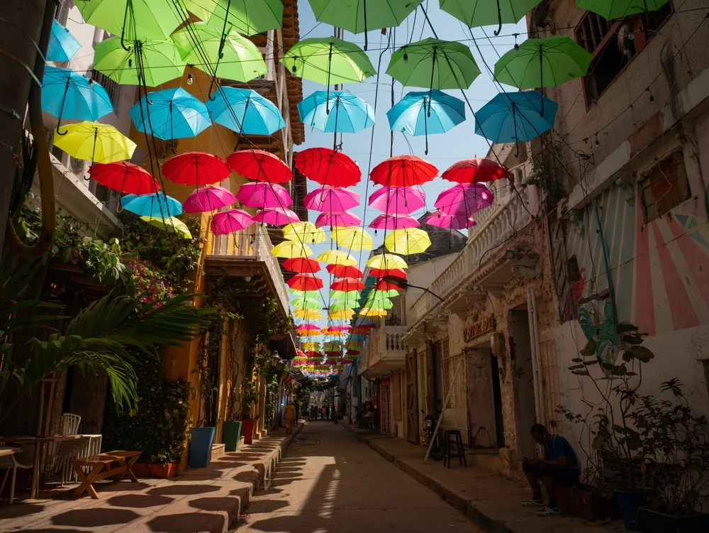 Unique alleyway with colorful umbrellas above the walking path in Cartagena