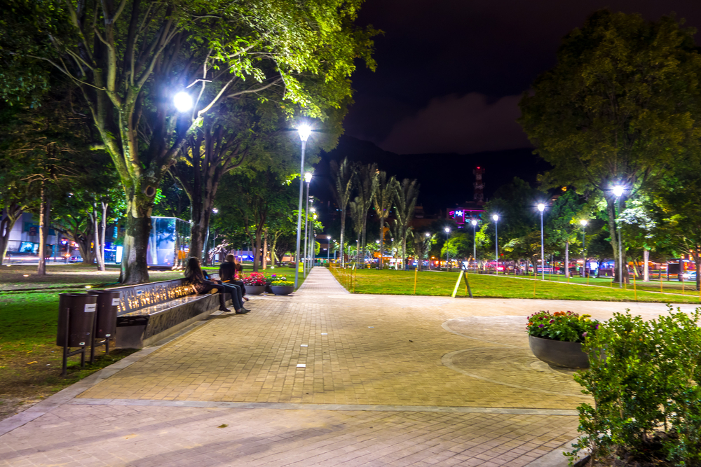 Parque de la 93 as seen at night with lights illuminating the expansive green grass