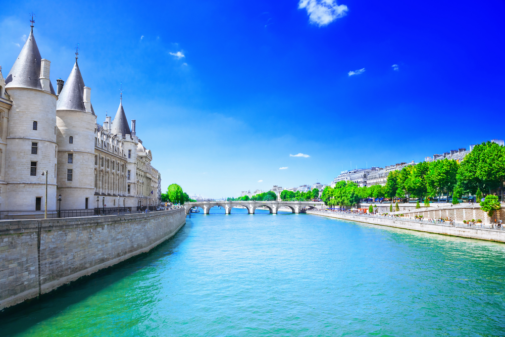 Seine River in Paris, as seen from a boat looking toward a bridge next to a stone walled building