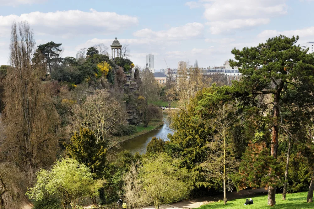 Buttes Chaumont Park, a top pick for must-visit places in Paris, pictured from a hilltop looking out over the city