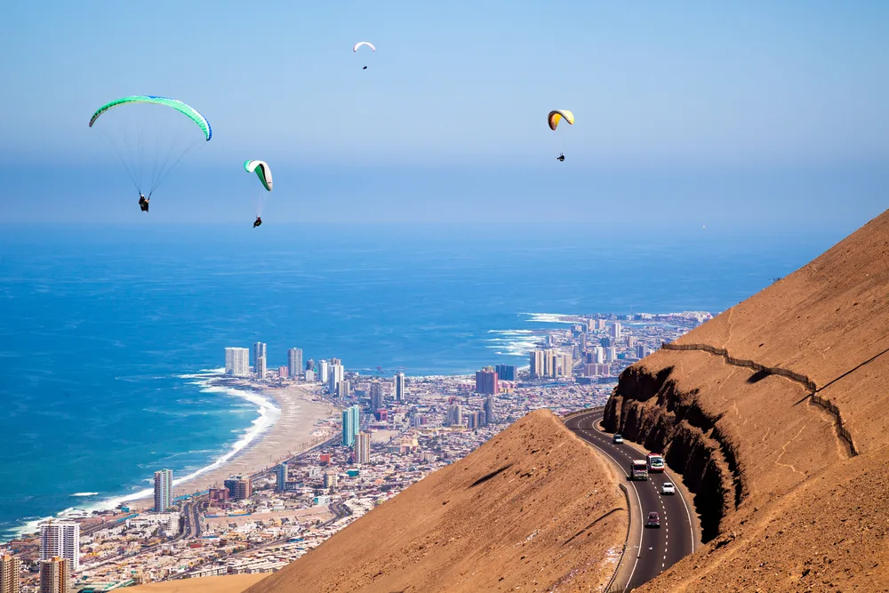 Paragliders fly over the hills of Iquique, one of the best places to visit in Chile