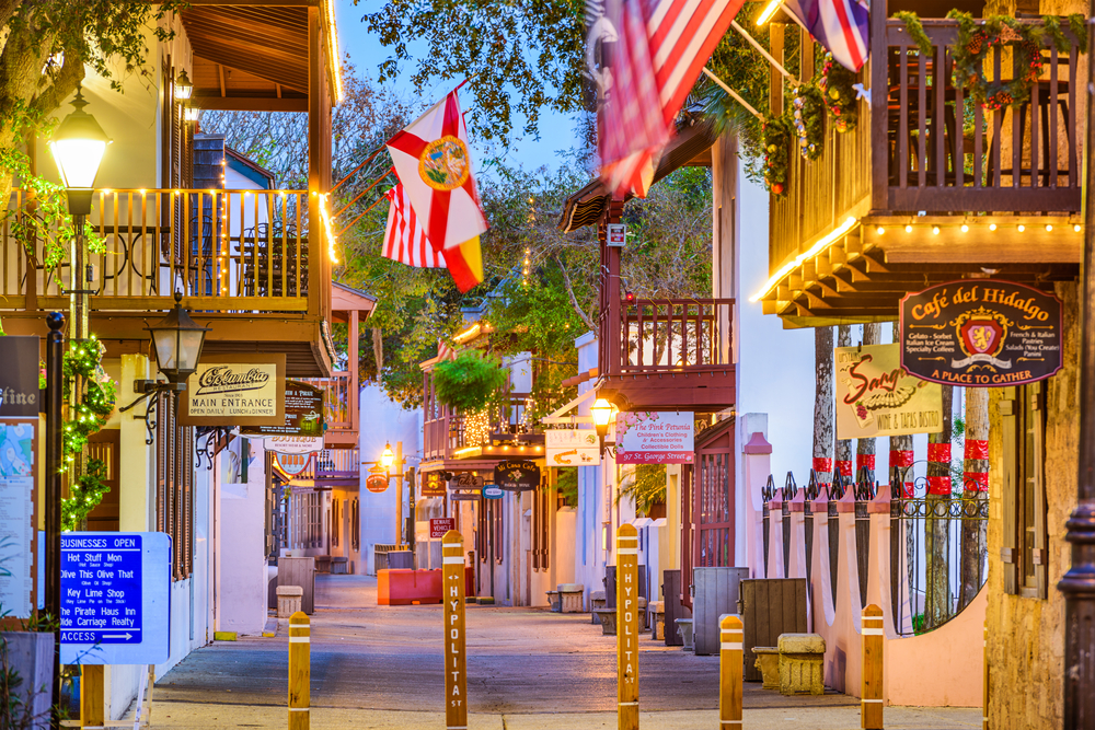 Little shops on either side of a quaint well-lit walkway in St. Augustine, Florida, pictured during the best time to visit