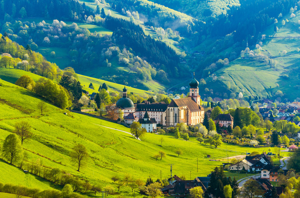 A building with an onion-shaped dome sits in the valley surrounded by mountains in the Black Forest, one of the best places to visit in Germany