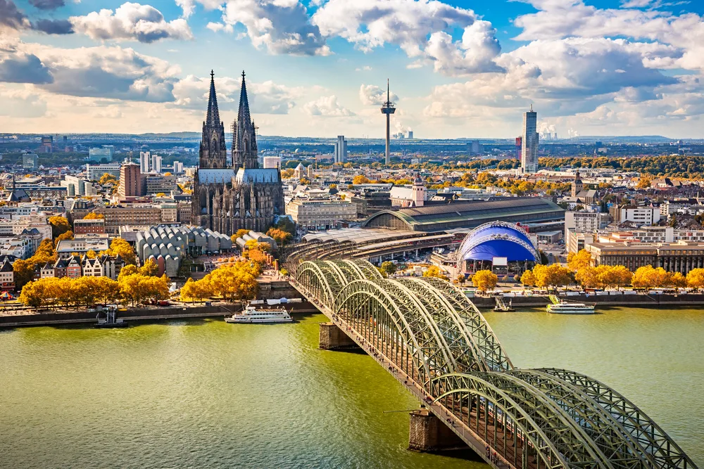 Aerial image of a cathedral and several steel bridges spanning a murky river in Cologne