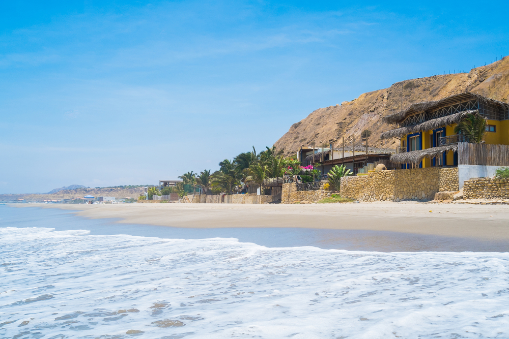 Little wood and thatch homes on the beach in Punta Sal, Mancora, one of Peru's best places to visit