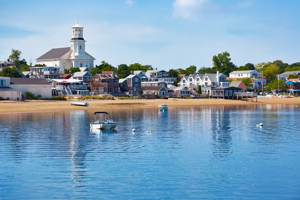 Calm day in one of the Northeast's best places to visit, Cape Cod (specifically Provincetown) pictured from a boat looking toward the shore
