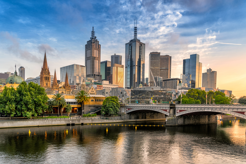 Oceanfront view of Melbourne, one of the must-visit places in Australia, pictured with a bridge over the water leading downtown
