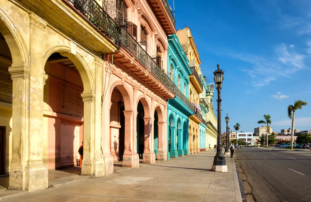 Havana street view with colorful buildings lining the street with archways in Cuba, where Americans can sometimes travel legally