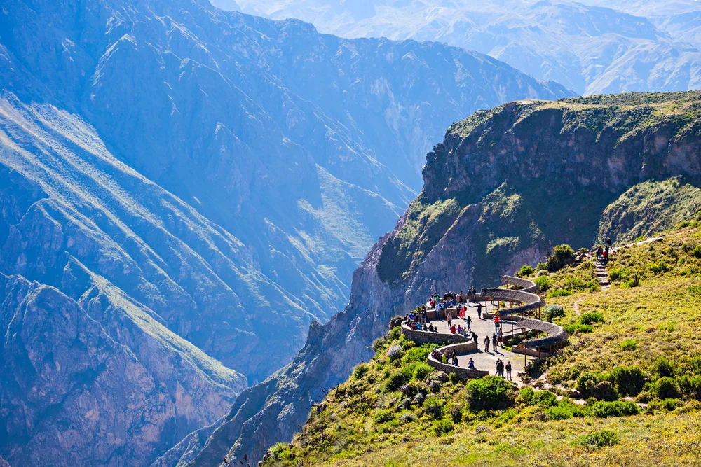 Steep cliffside viewing point at Colca Canyon pictured with a stunning view of the valley below in full view of the reader