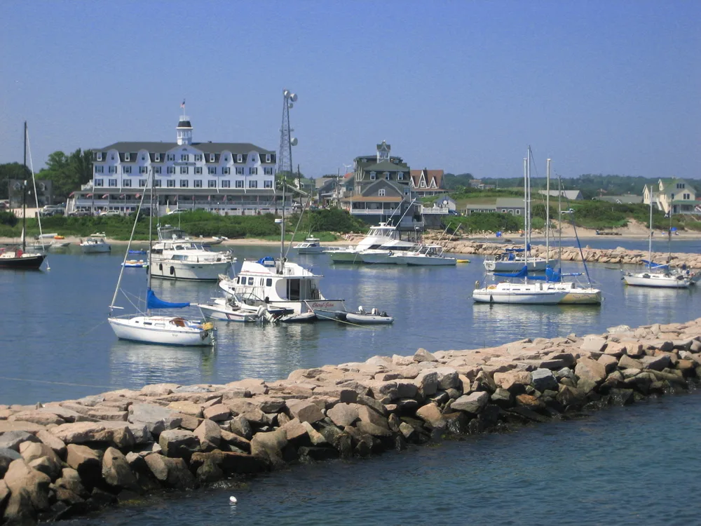 The harbor in Block Island, one of the best day trips from Boston, pictured with a rocky jetty around the boats