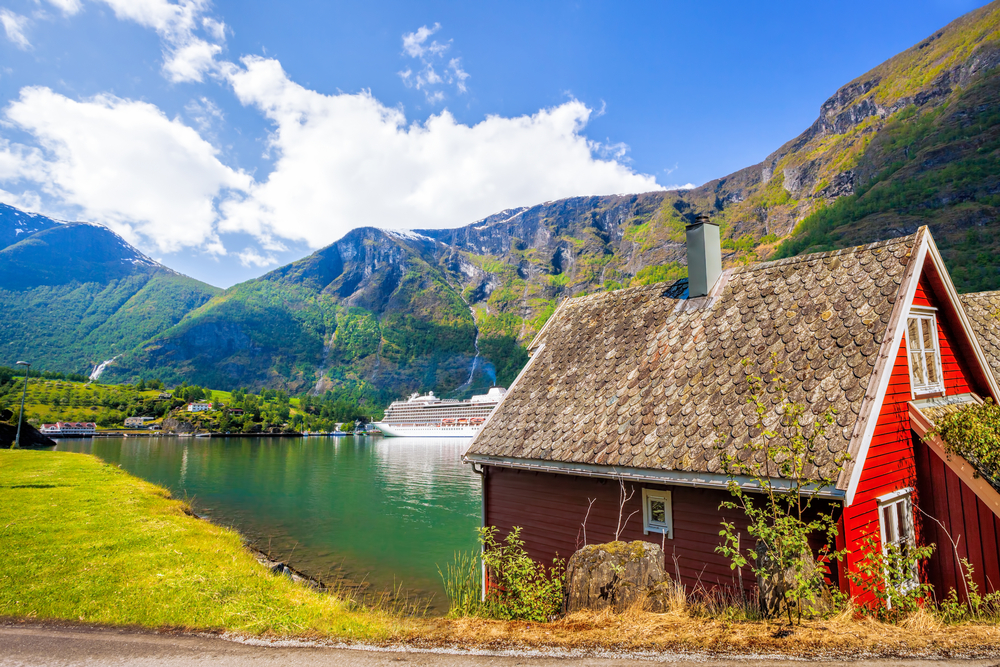 Idyllic red hut along the banks of a lake in Flam, Norway, one of the best places to visit on a trip to the country
