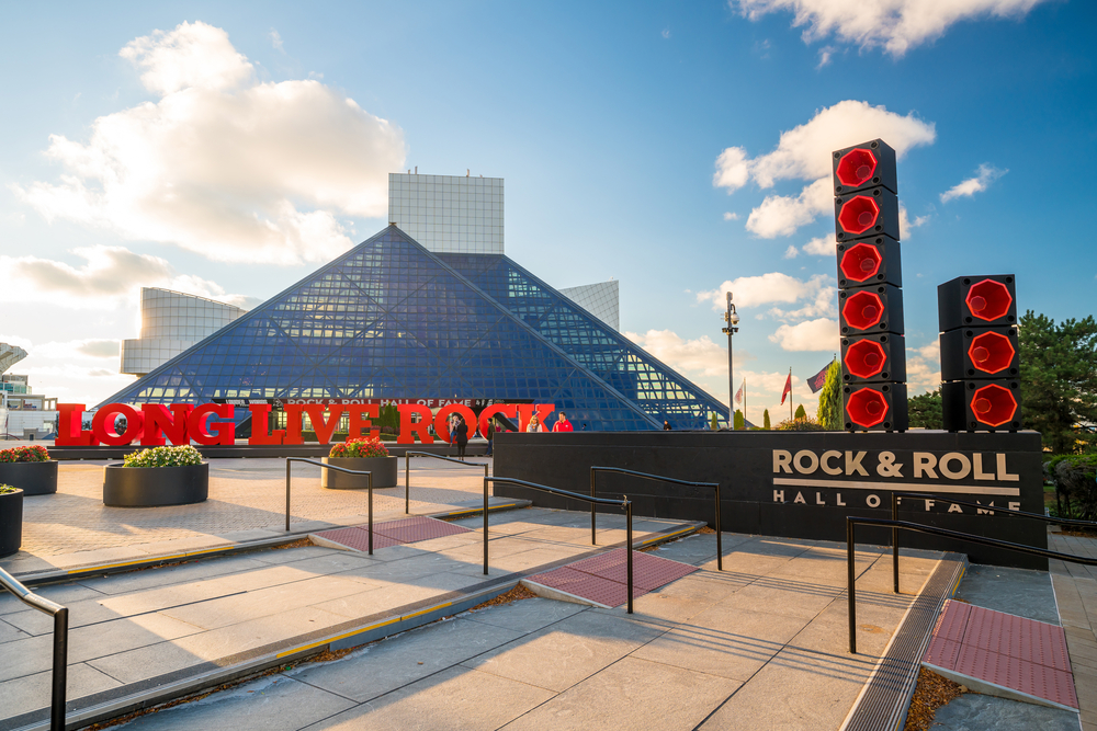 Exterior of the Rock and Roll Hall of Fame pictured against a blue sky with clouds on the horizon