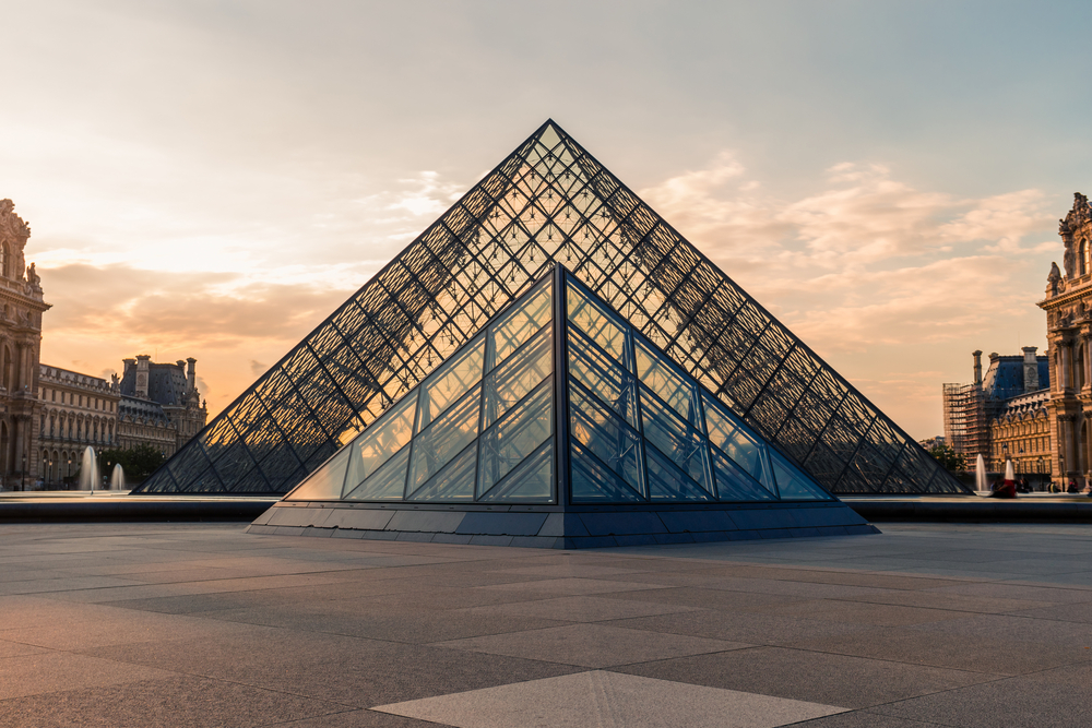 Evening view of the Louvre Museum and its iconic glass pyramid for a piece on the best places to visit in the world