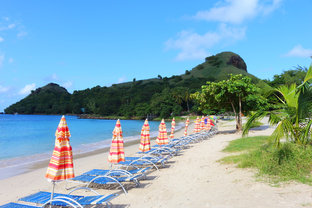 Pictured during the best time to visit St. Lucia, a bunch of loungers and umbrellas sit on the beach