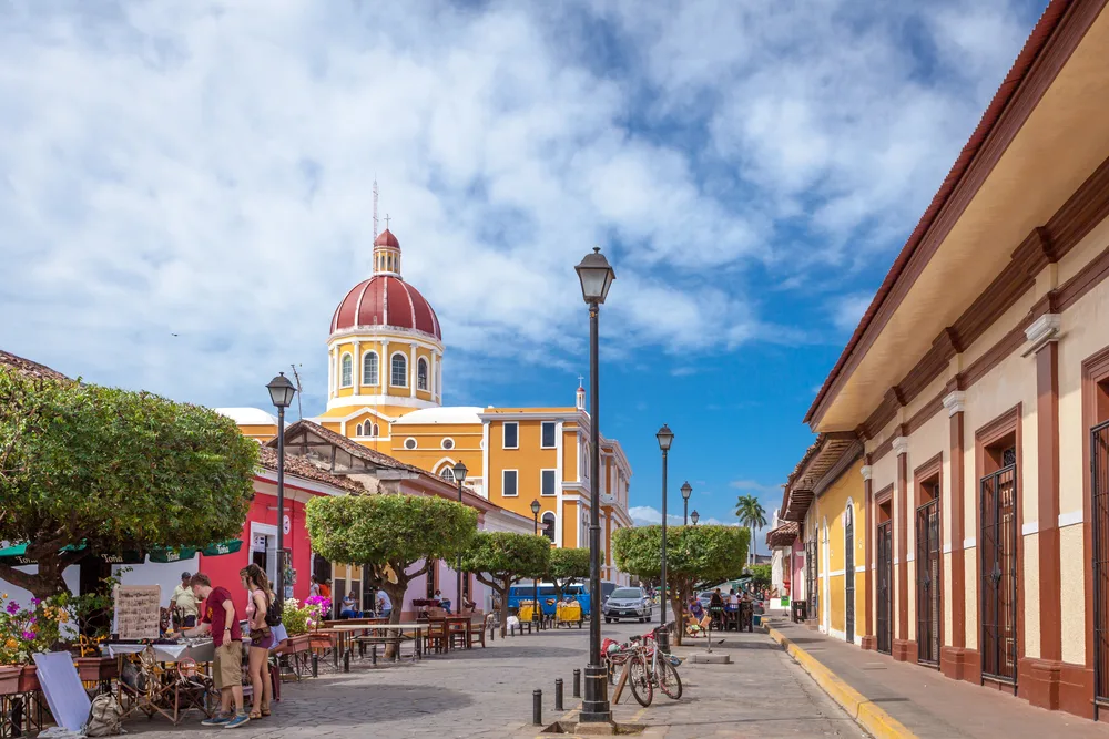 Stunning view of the empty streets in Granada, Nicaragua, with its lampposts lining the streets and an orange church in the background