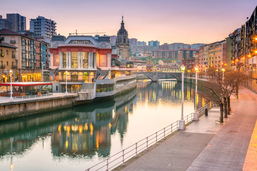 Sunrise over the food market in Bilbao in Spain with the river running next to some historic old buildings