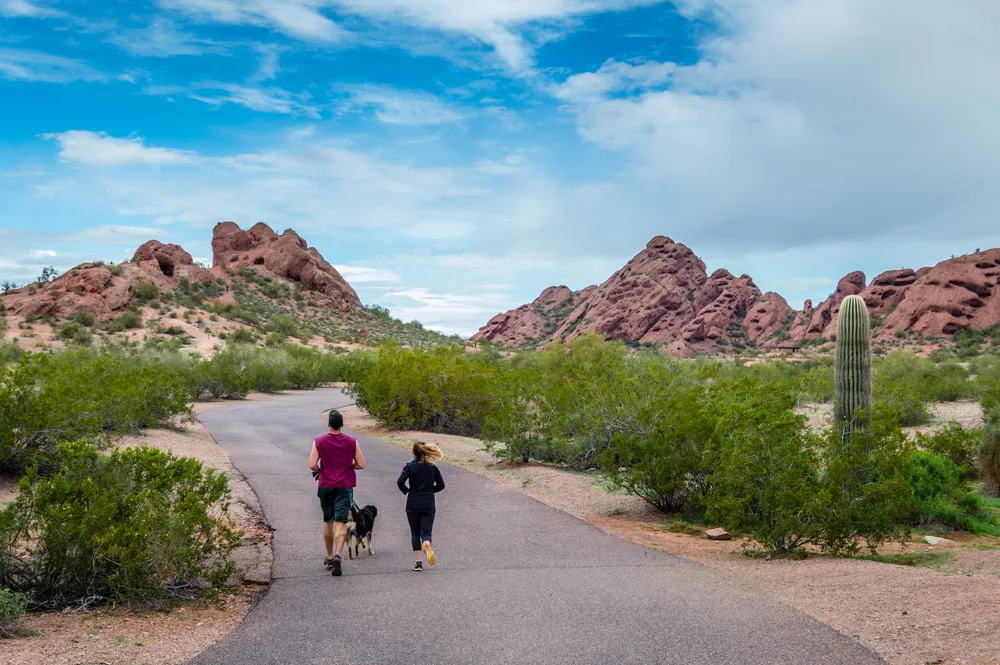 Middle-aged couple jog down the walking path at Papago Park on Scottsdale Road, one of the best parts of Scottsdale in which to stay