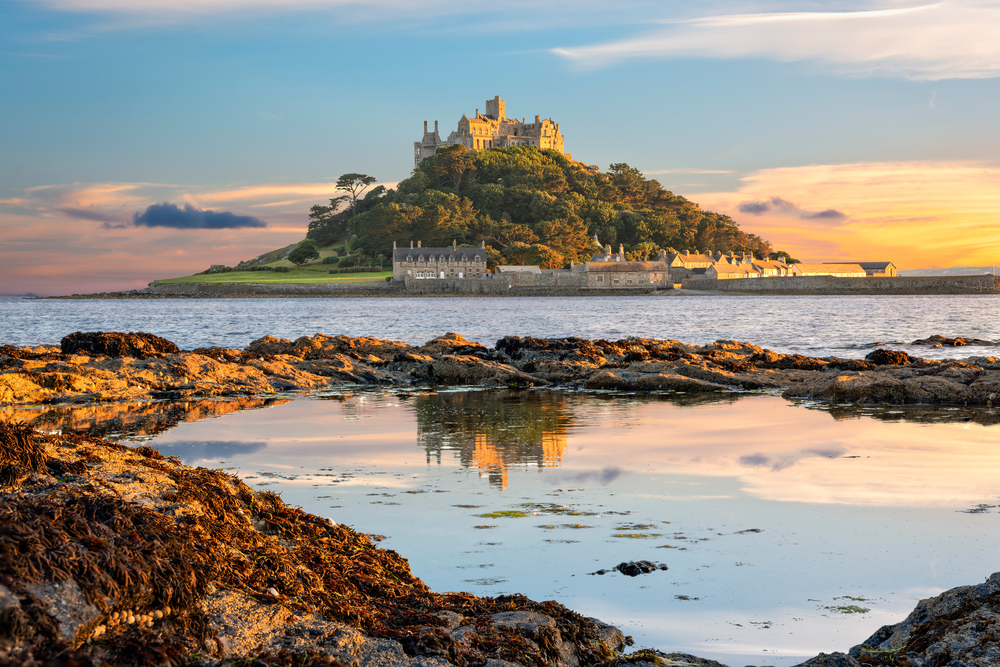 St. Michael's Mount pictured on an island in the distance as seen from the shoreline as one of the best places to visit in England